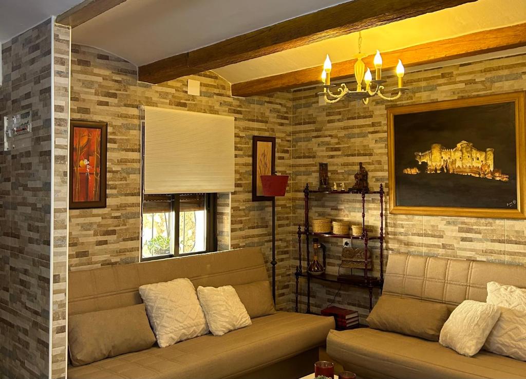 贝尔蒙特Casa Rural La Simona的带沙发和砖墙的客厅