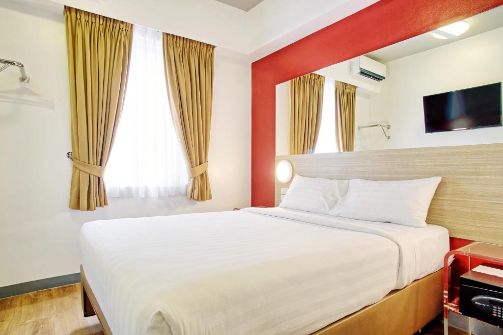 马尼拉Red Planet Manila Aseana City的酒店客房,配有床和电视