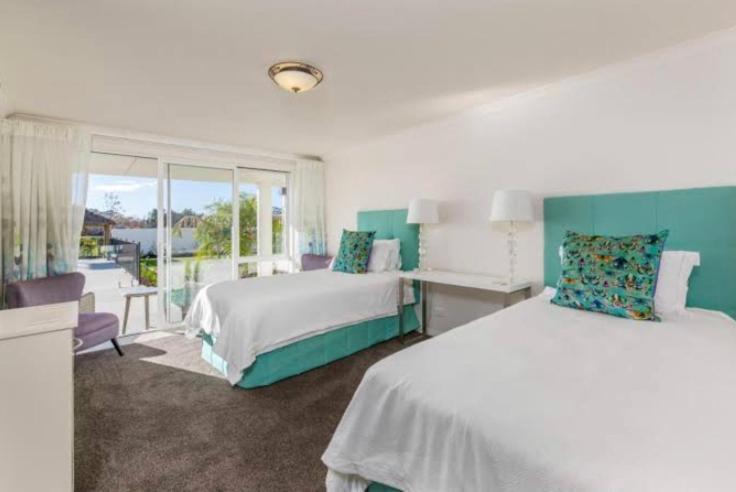 凯里凯里Te Whare Ma的一间卧室设有两张床和大窗户