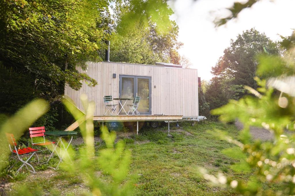 奥斯特罗德Green Tiny Village Harz - Tiny House Pioneer 7的院子内的小房子,配有桌椅