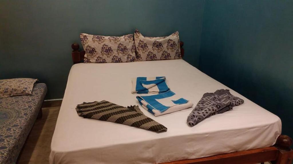 卡兰古特La Gabriell beach inn的一张带两个枕头和袜子的白色床