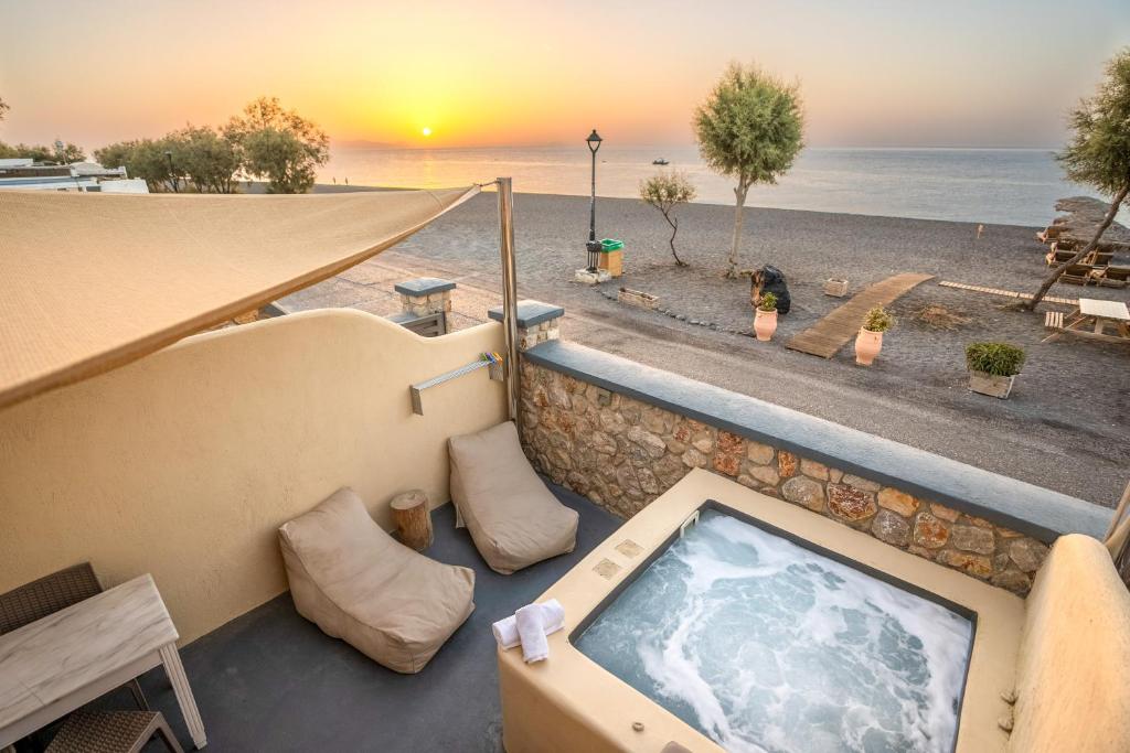 佩里沃罗Cyclops Beach Apartments的海滩景阳台的热水浴池
