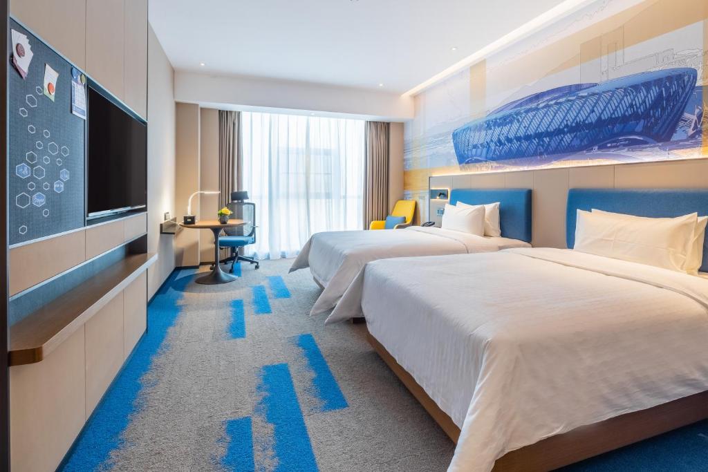 青山武汉高铁站希尔顿欢朋酒店的酒店客房设有两张床和一台平面电视。