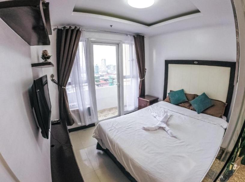 马尼拉FREE SAUNA & POOL ACCESS PLUS 70 PERCENT LESS PROMO This Month Affordable And Cheapest Deluxe FAMILY Unit In Manila with Balcony x Near NAIA Airport x Manila Bay x Robinsons Place Ermita x Pgh x Bellagio x UP x Intramuros x Updated 2024 Price Staycation的一间卧室设有一张床和一个大窗户