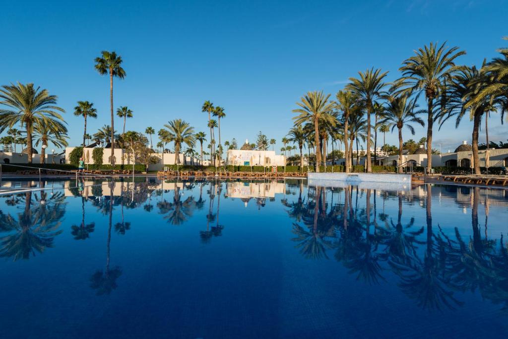 英格兰海滩HD布拉格克里斯托巴尔格兰卡纳里阿酒店的一座棕榈树和蓝天游泳池