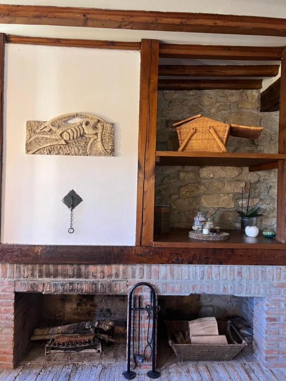 ArmañoCasa Rural Basiver - Habitación Pico Samelar的砖砌壁炉,配有木制壁炉