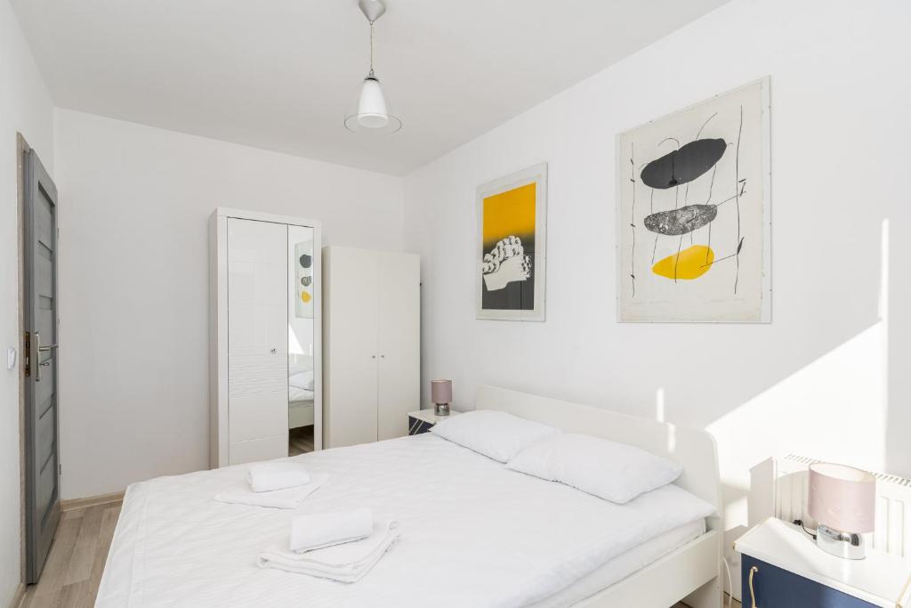 克拉科夫Borkowska Standard Apartment的白色卧室配有床和镜子
