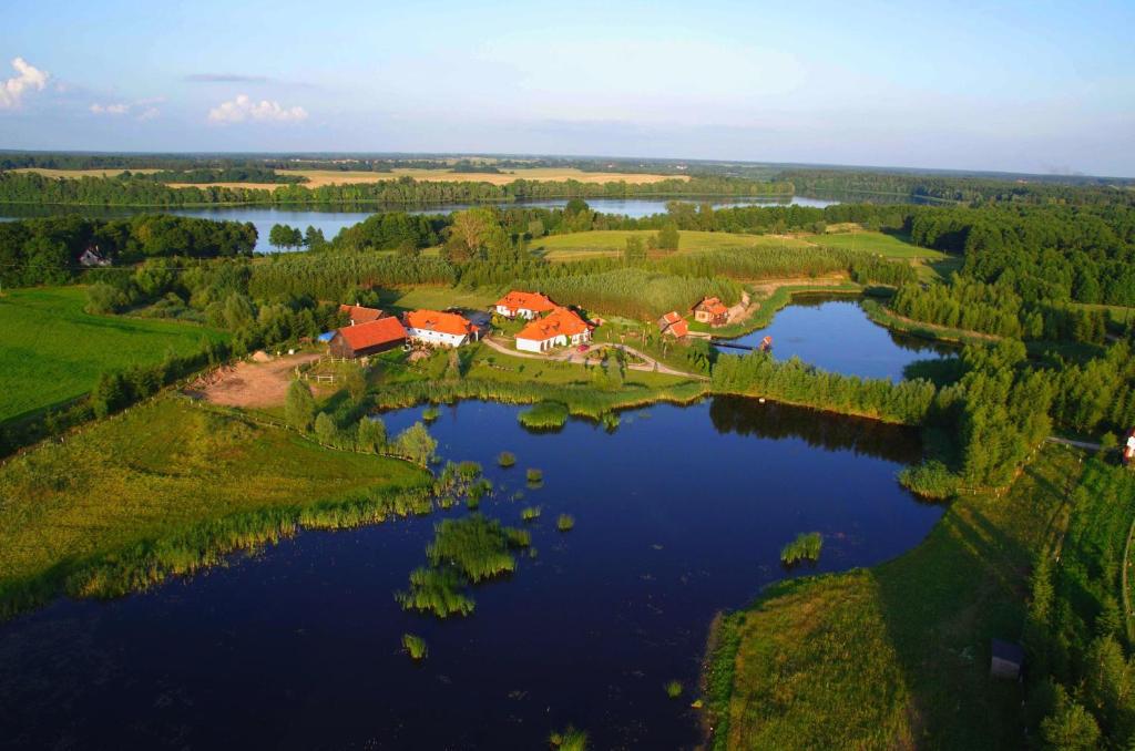 奥莱茨科Siedlisko Konradówka的湖上岛屿上房屋的空中景观