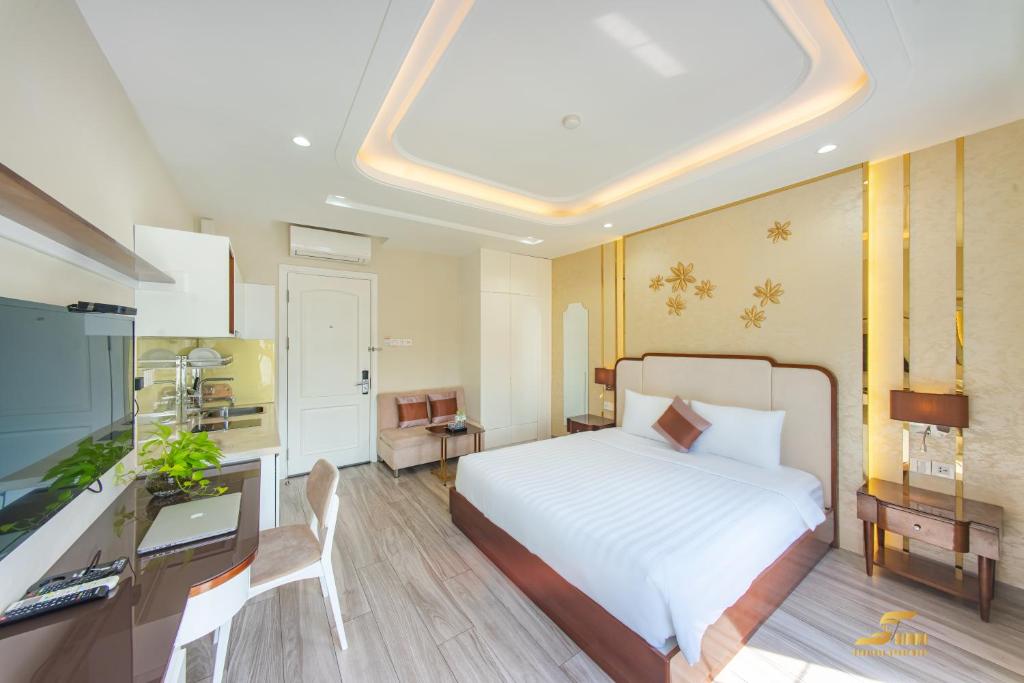 胡志明市Simmi Apartment Phu My Hung的一间卧室配有一张床、一张书桌和一台电视