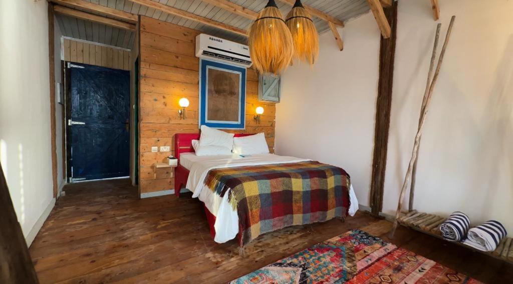 拉斯阿尔卡麦Banan Beach的卧室配有一张床铺,位于带木墙的房间内