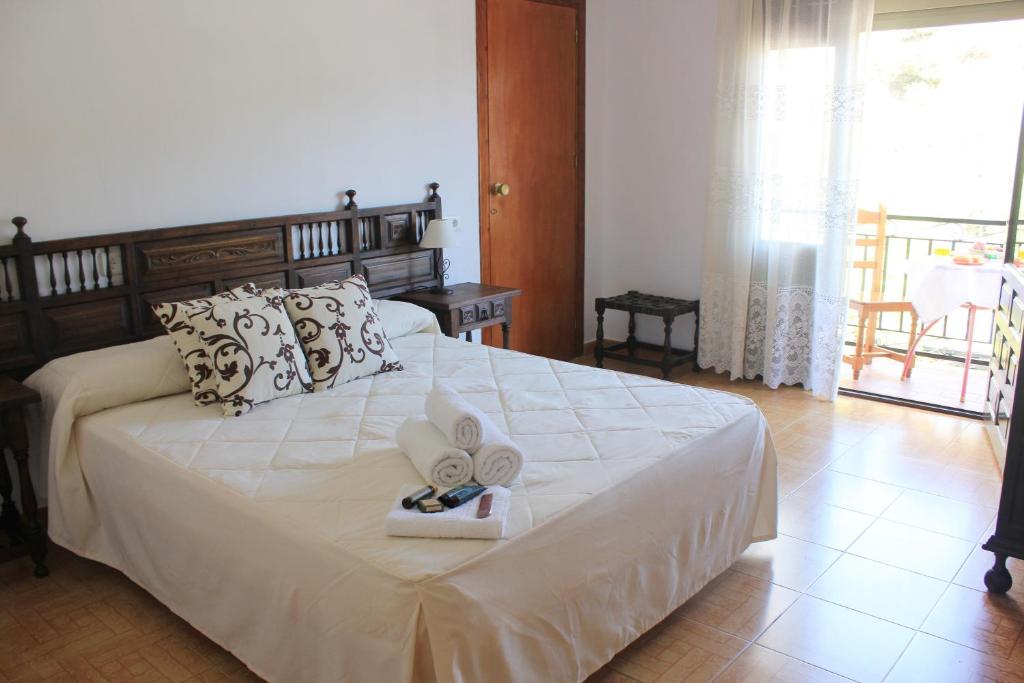 阿尔加罗沃Pensión Algarrobeña的一间卧室配有一张床,上面有两条毛巾