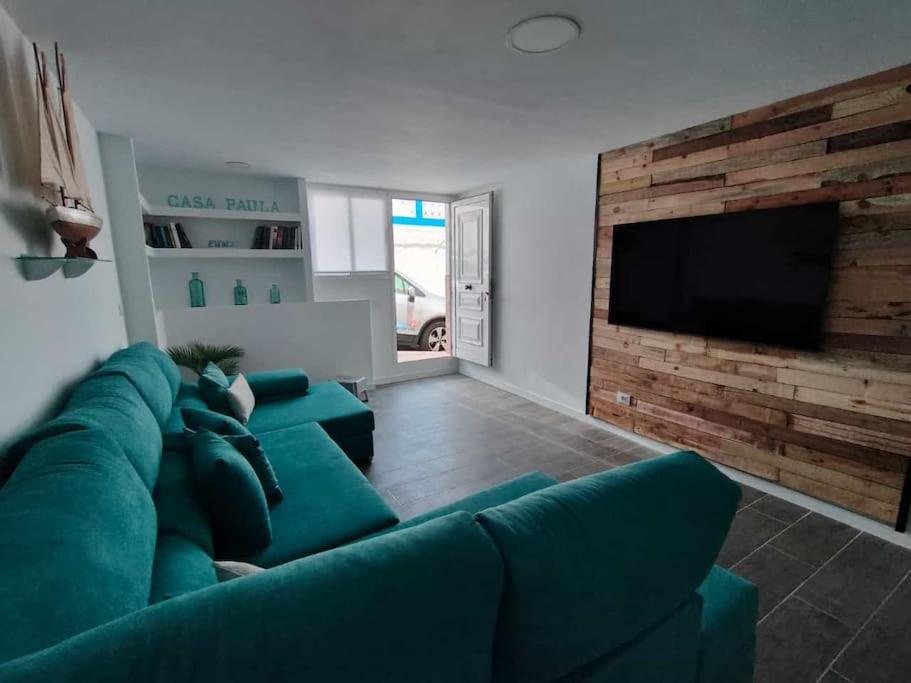 普雷塔斯Casa Paula的客厅配有绿色沙发和平面电视