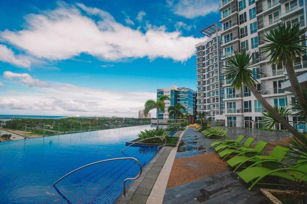 Punta EngañoMactan Newtown 2 Bedroom near Mactan Airport的一座棕榈树游泳池和一座建筑