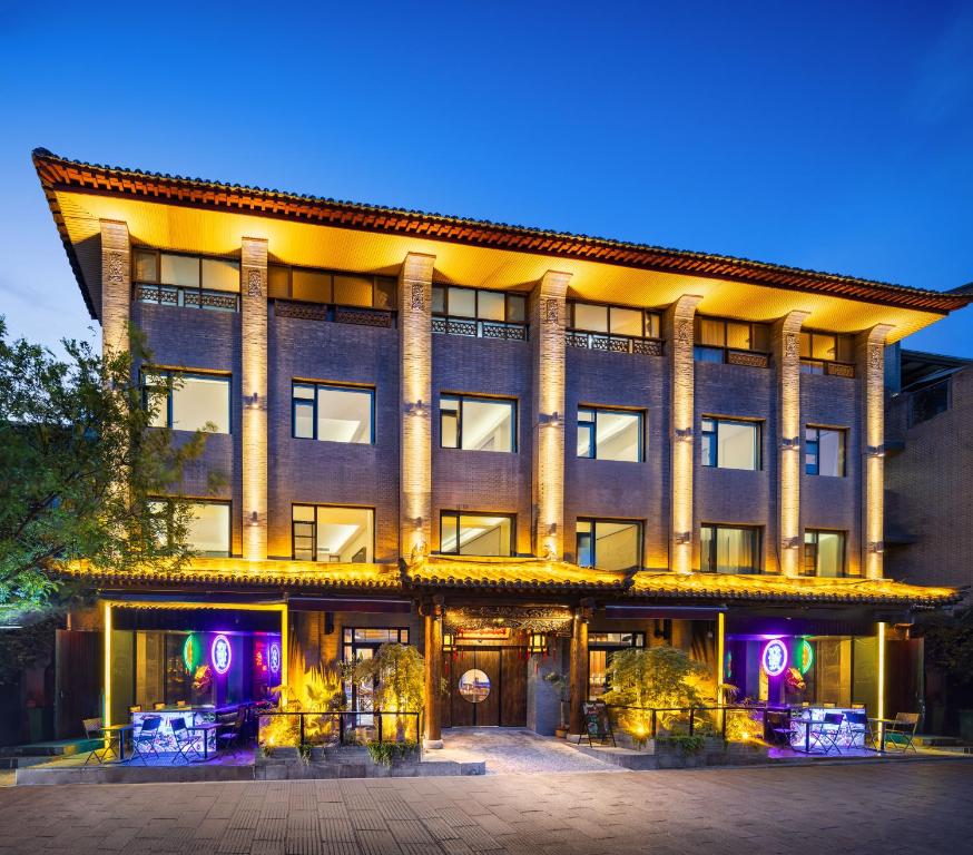 西安鸿胪花园酒店的一座大建筑前面有紫色的灯