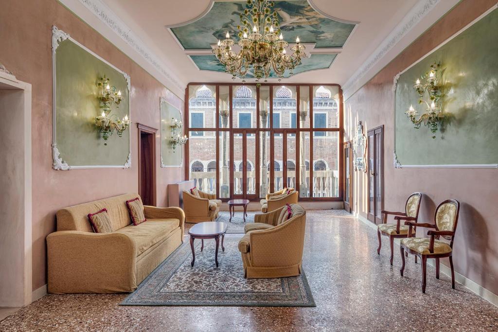 威尼斯保萨尼亚酒店的客厅配有家具和吊灯。