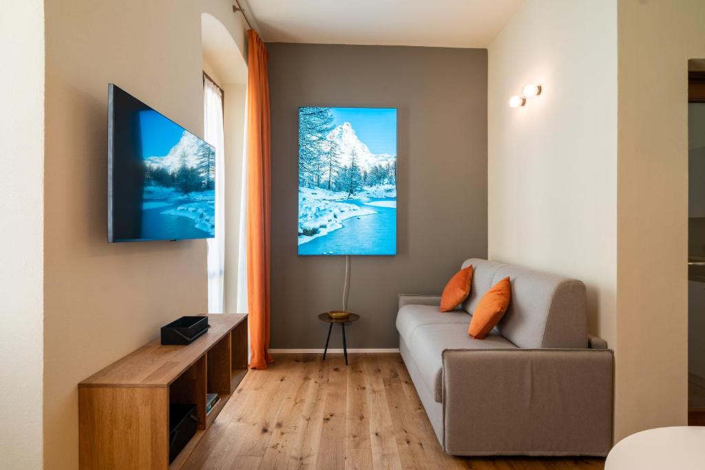 奥斯塔Aosta Holiday Apartments - Sant'Anselmo的带沙发和电视的客厅