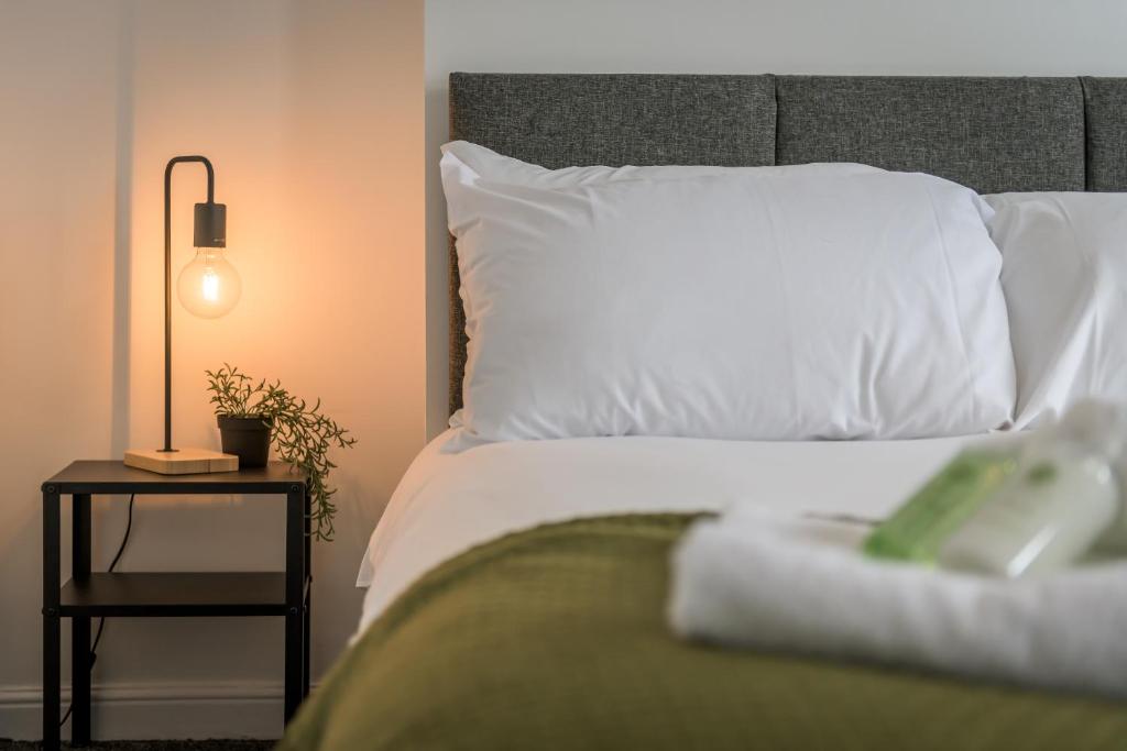 凯特林Wood House - 5 Beds, Suitable for contractors的一张带白色枕头和边桌的床