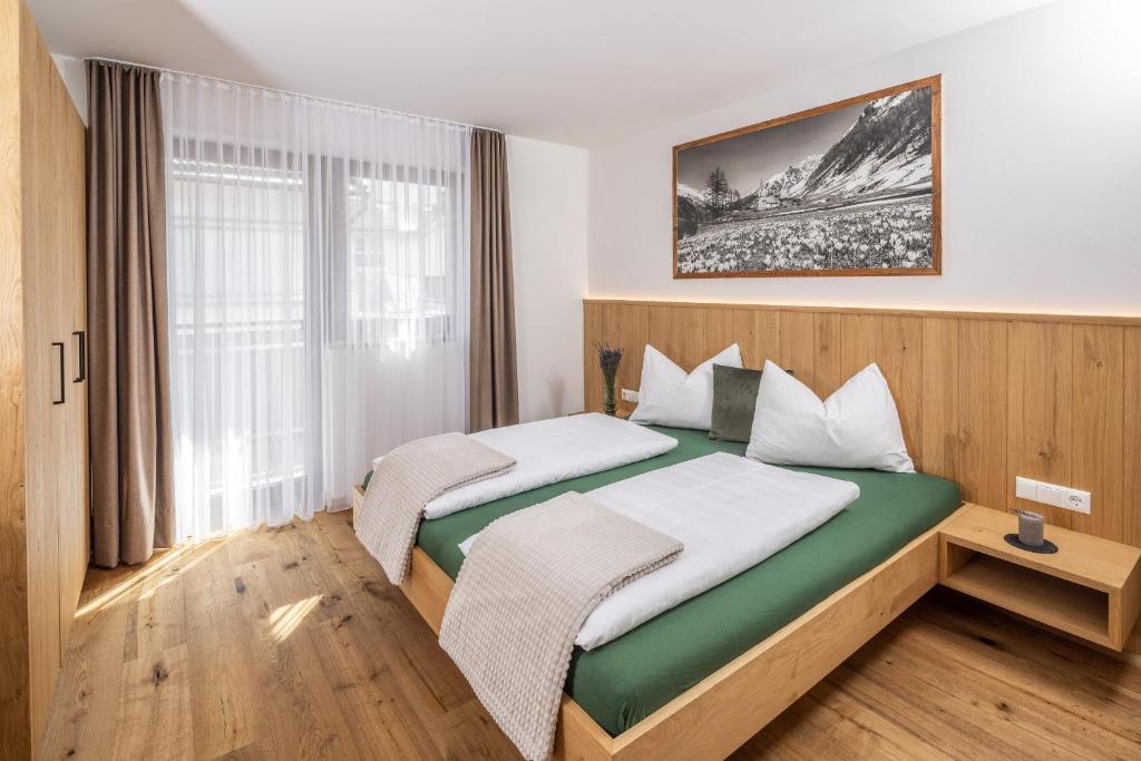 卢塔戈Zum Sonnentor App Larix 2的一间卧室设有两张床和窗户。
