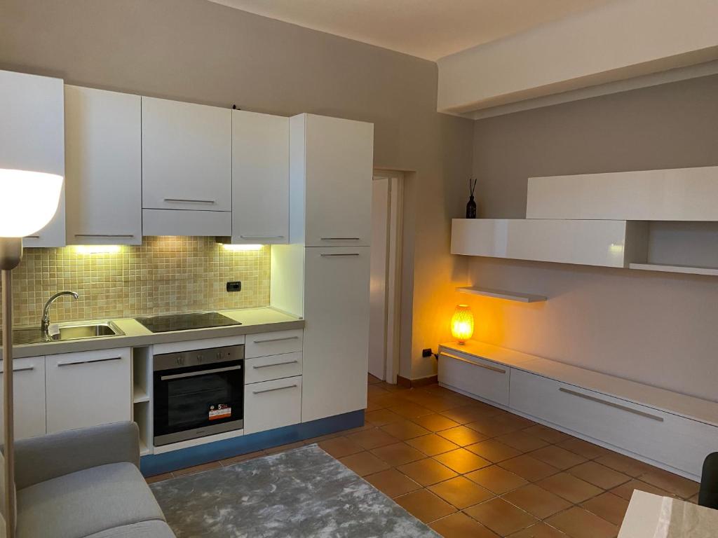 米兰Cozzi Apartment的厨房配有白色橱柜、水槽和沙发。