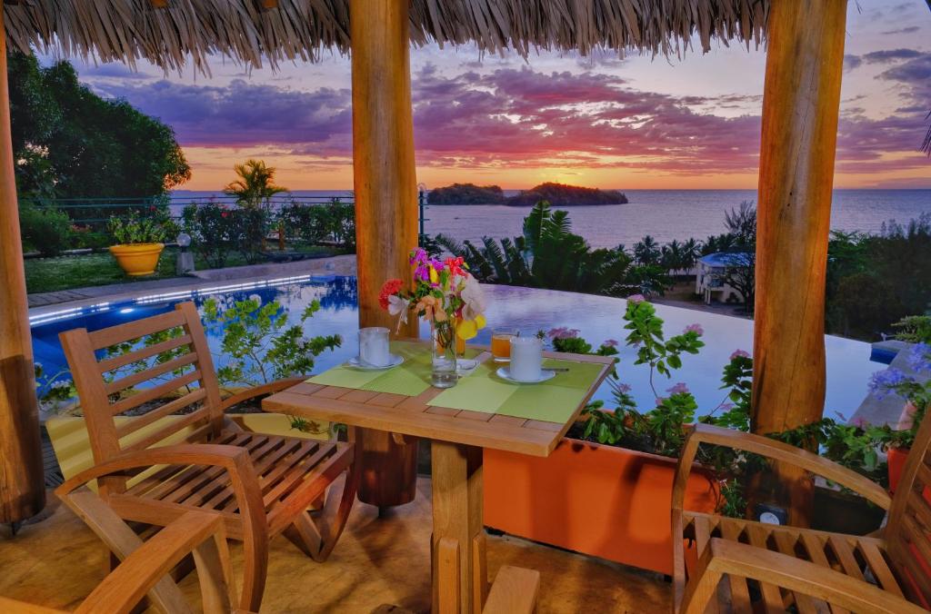 贝岛VILLA PANORAMA NOSY BE的海景门廊上的桌椅