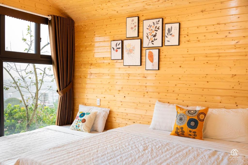 木州县Avatar Homestay & Coffee - Mộc Châu的卧室配有两张床,墙上挂有图片