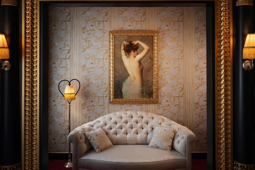 巴黎Maison Souquet, Hotel & Spa的一张沙发房间里一幅女人的画