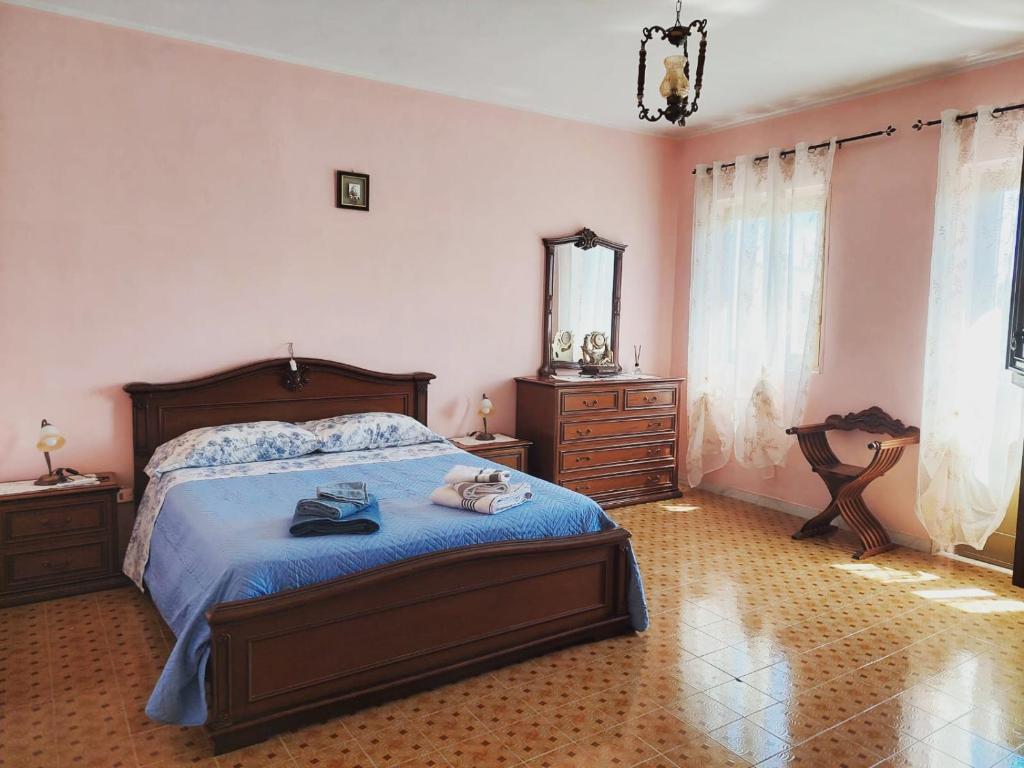 MacchiagodenaB&B da Manuela的一间卧室配有一张带蓝色床单和镜子的床