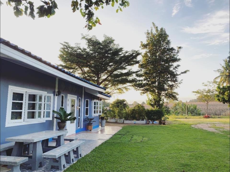 王南安科บ้านสวนจันทร์เจ้า的庭院里带野餐桌的蓝色房子