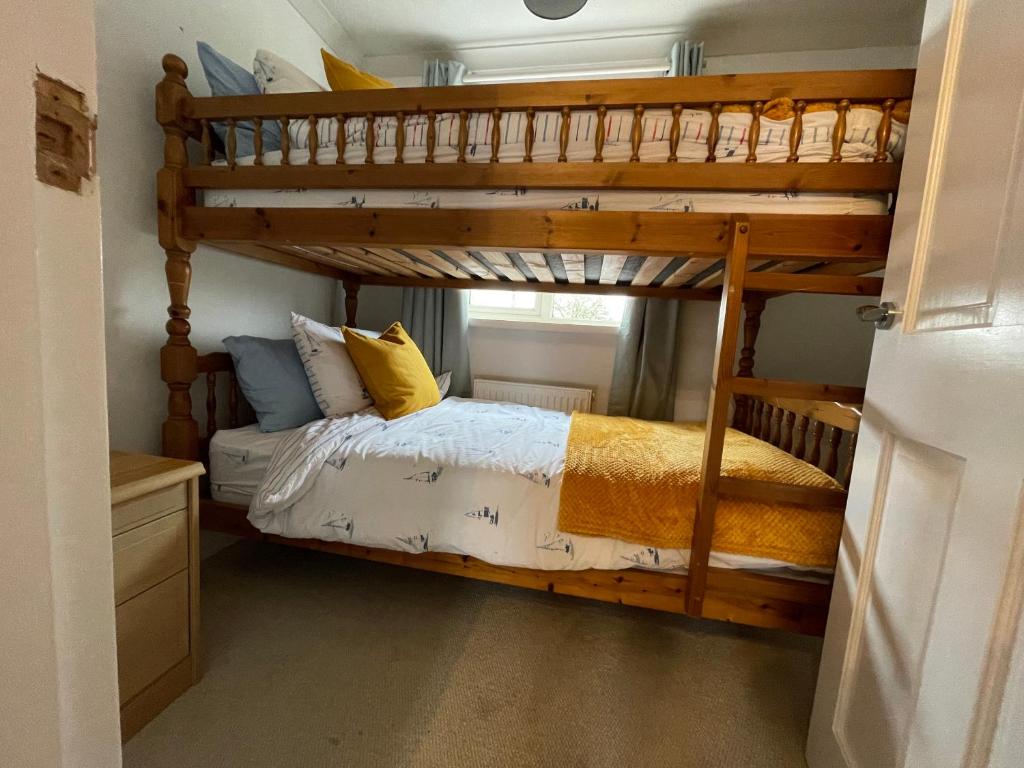BaconsthorpeCharming North Norfolk flint cottage的一间卧室配有双层床