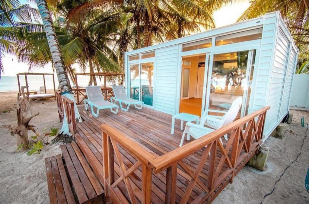 圣安德烈斯Hotel Reina del Mar By Dorado的海滩上的蓝色房屋,配有桌椅