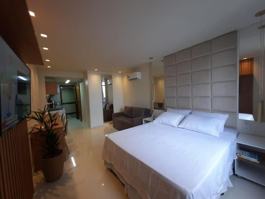 萨尔瓦多OITO ZERO UM - Flat Sol Victoria Marina的卧室配有一张白色的大床和一张沙发。