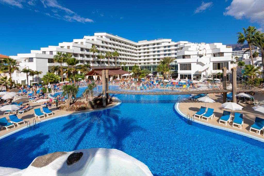 美洲海滩特内里费最佳酒店的一个带椅子的度假游泳池和一间酒店