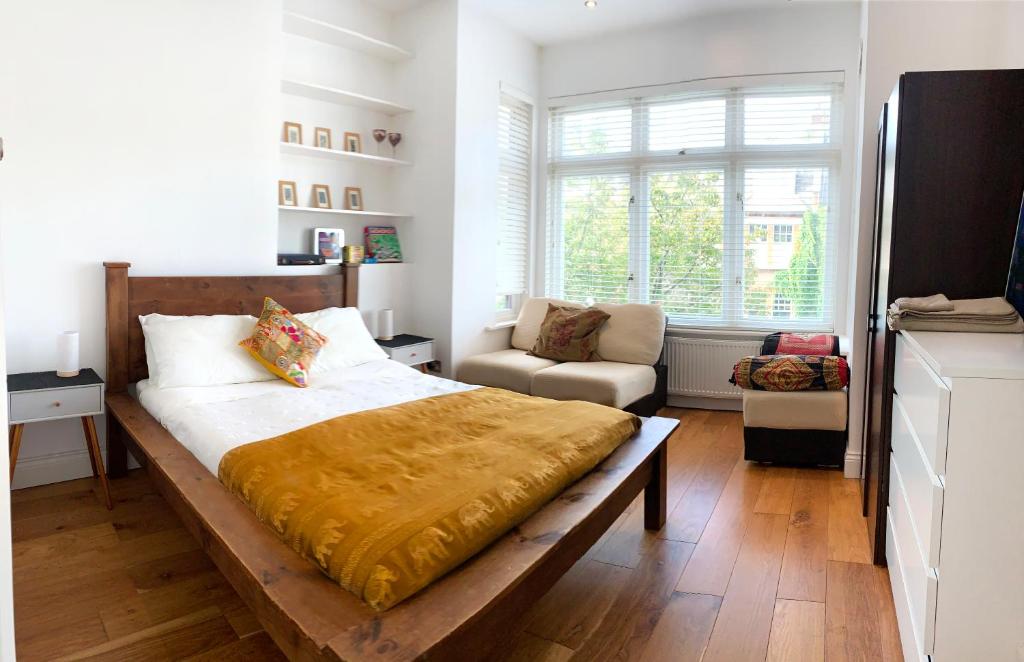 伦敦Central Location 2 bed flat, Zone II, London NW6的一间卧室配有一张大床和一把椅子