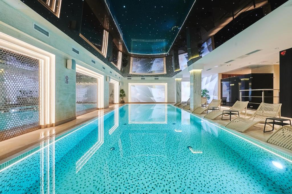 华沙Stay inn Hotel Warszawa的一座配有桌椅的酒店游泳池