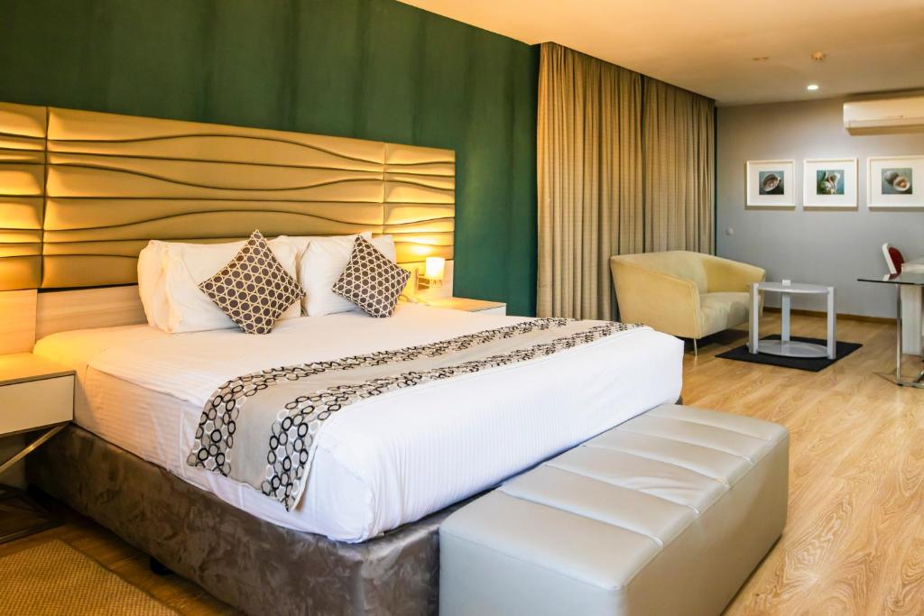 马普托WL Hotel Maputo City Center Mozambique Collection的酒店客房带一张大床和一把椅子