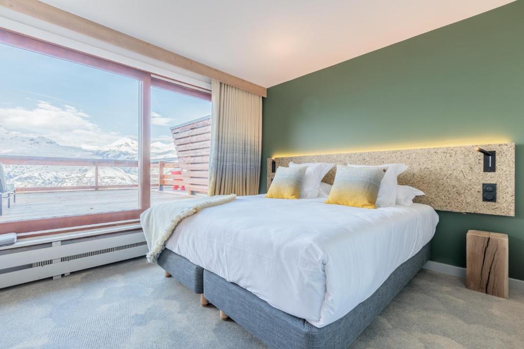 阿克 1600La Cachette, Friendly Hotel & Spa的一间卧室设有一张大床和一个大窗户