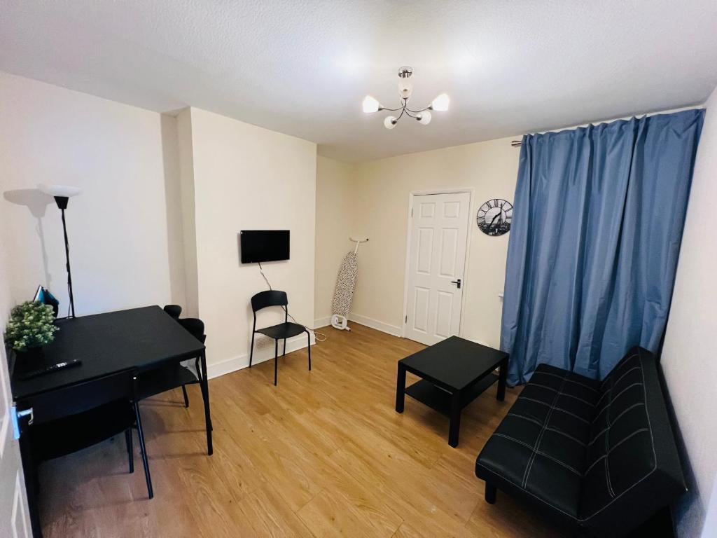 伦敦Three Bedroom House with private car park的客厅配有钢琴和蓝色窗帘