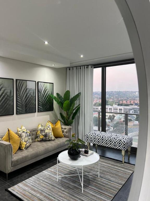 约翰内斯堡@ORRIE Apartments Infinite的客厅配有沙发和桌子