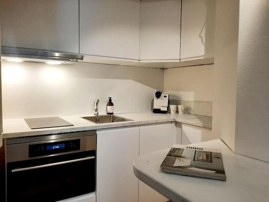 赫尔辛基Top-floor studio, near park & sea, great transit的厨房配有白色橱柜、水槽和炉灶。