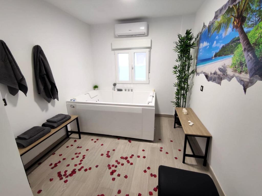 卡拉塔尤德apartamento con jacuzzi, El Rincón de Ayud的浴室铺有红色的落叶,设有白色的浴缸和红色的落叶。