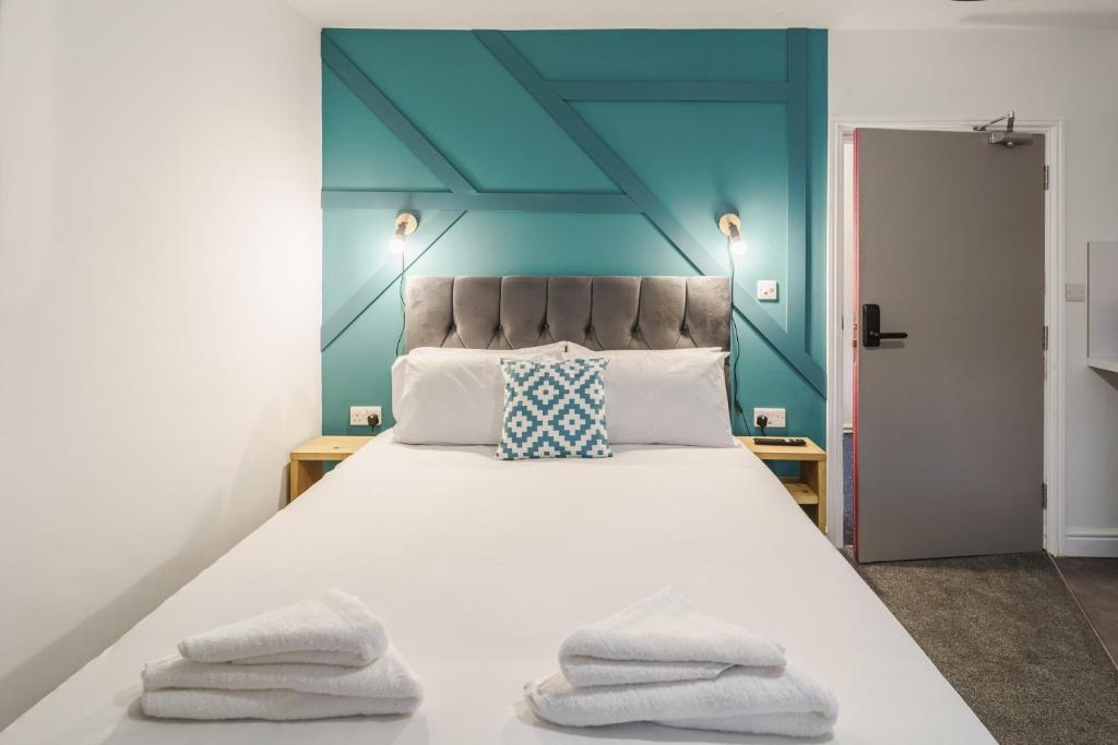 德比Deluxe Studio Apartments的一间卧室配有一张大床和毛巾