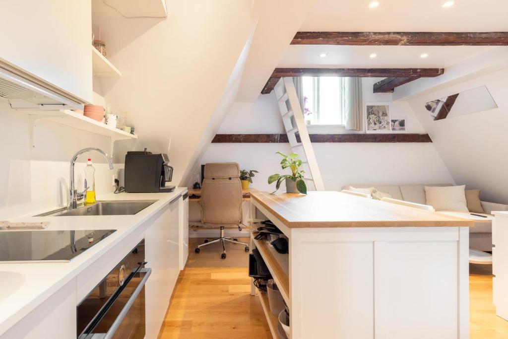 哥本哈根Charming Loft City Center的阁楼厨房配有白色橱柜和水槽