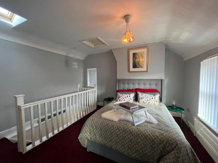 锡福斯The Townhouse in Waterloo sleeps 4的一间卧室配有红色枕头的床