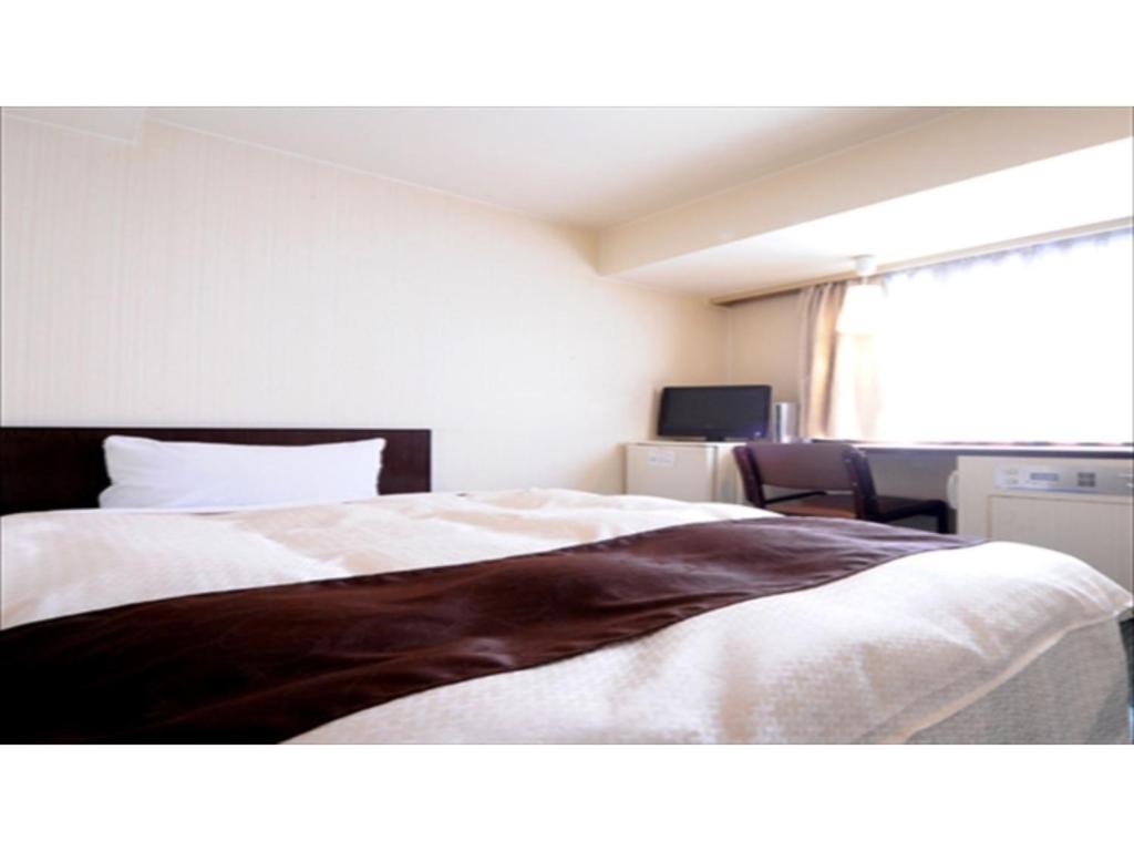 广岛Hiroshima Kokusai Hotel - Vacation STAY 54438v的一间卧室设有一张大床和一个窗户。