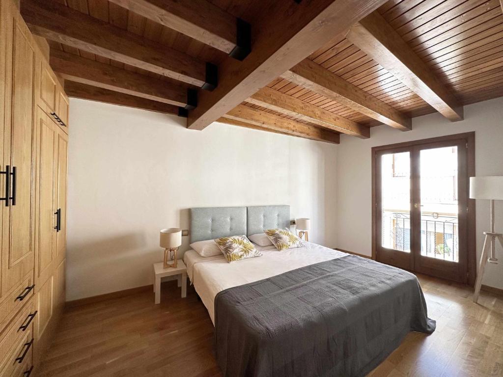 普奇塞达Casa Baronia La Cerdanya的一间带一张大床的卧室,位于一个拥有木制天花板的房间