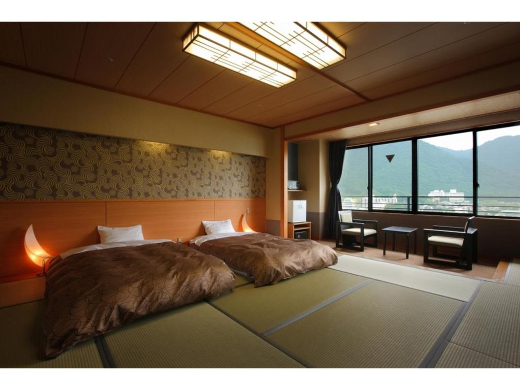 日光Kinugawa Onsen Yusuikiko Hotel Otaki - Vacation STAY 68843v的一间卧室设有一张大床和一个大窗户