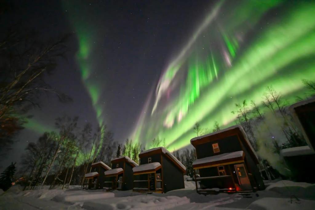 North PoleThe Lazy Lynx - Frontier Village的天空中一排有极光的小屋
