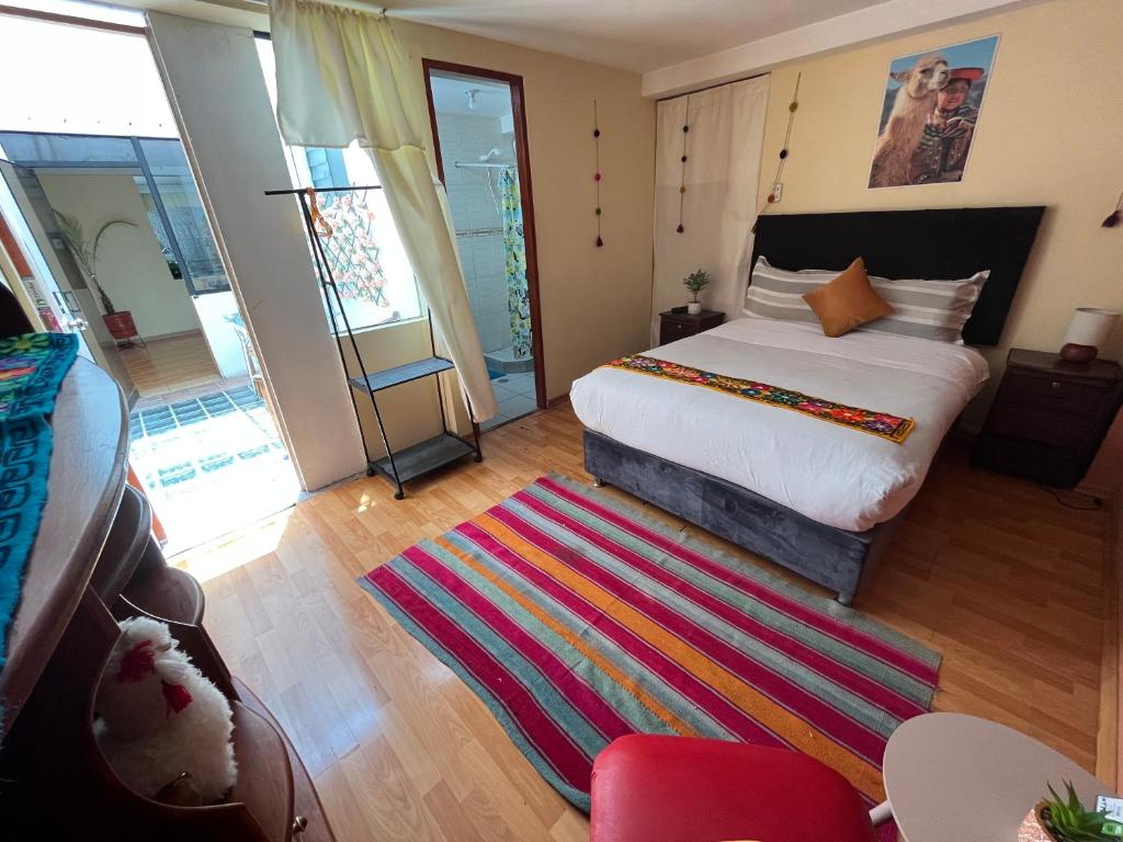 库斯科Cusco Rooms的一间卧室配有床和色彩缤纷的地毯。
