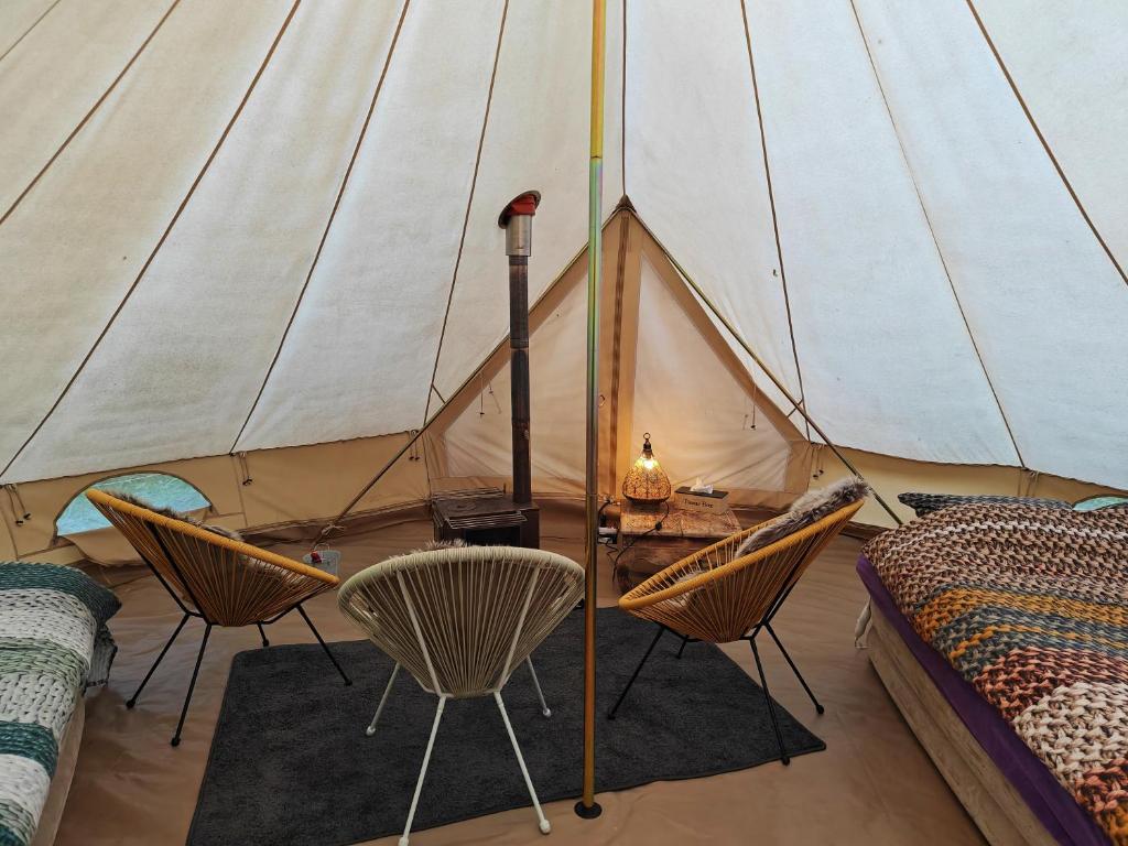 LabroyeAu Pied Du Trieu, the glamping experience的一个带椅子、一张床和一张桌子的帐篷