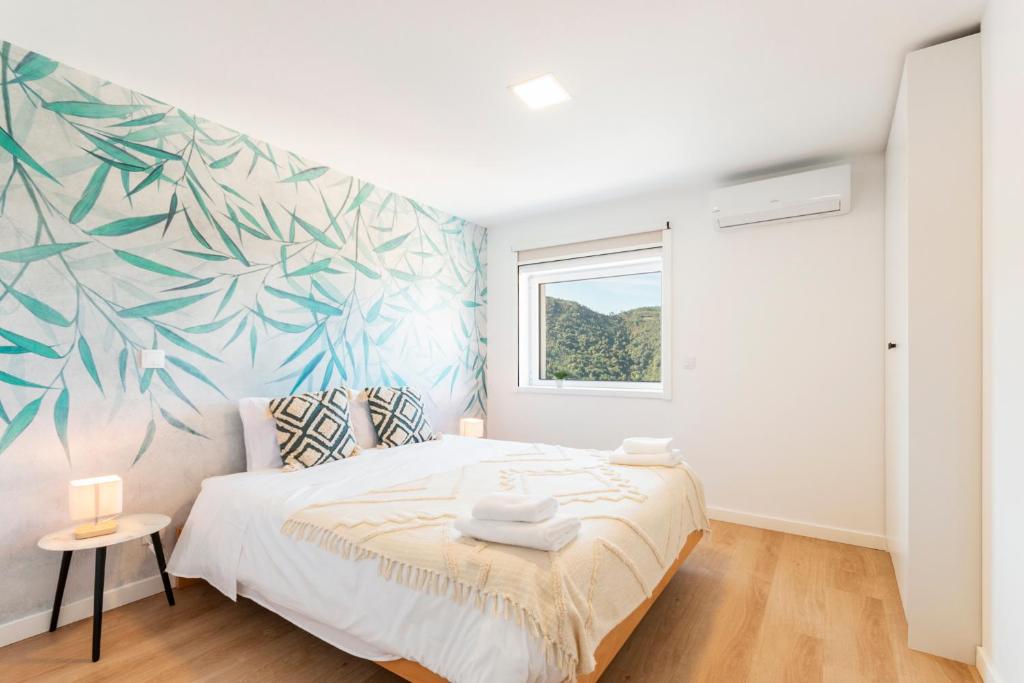 洛里加Loriga View Apartments的卧室配有一张带热带壁画的床铺。
